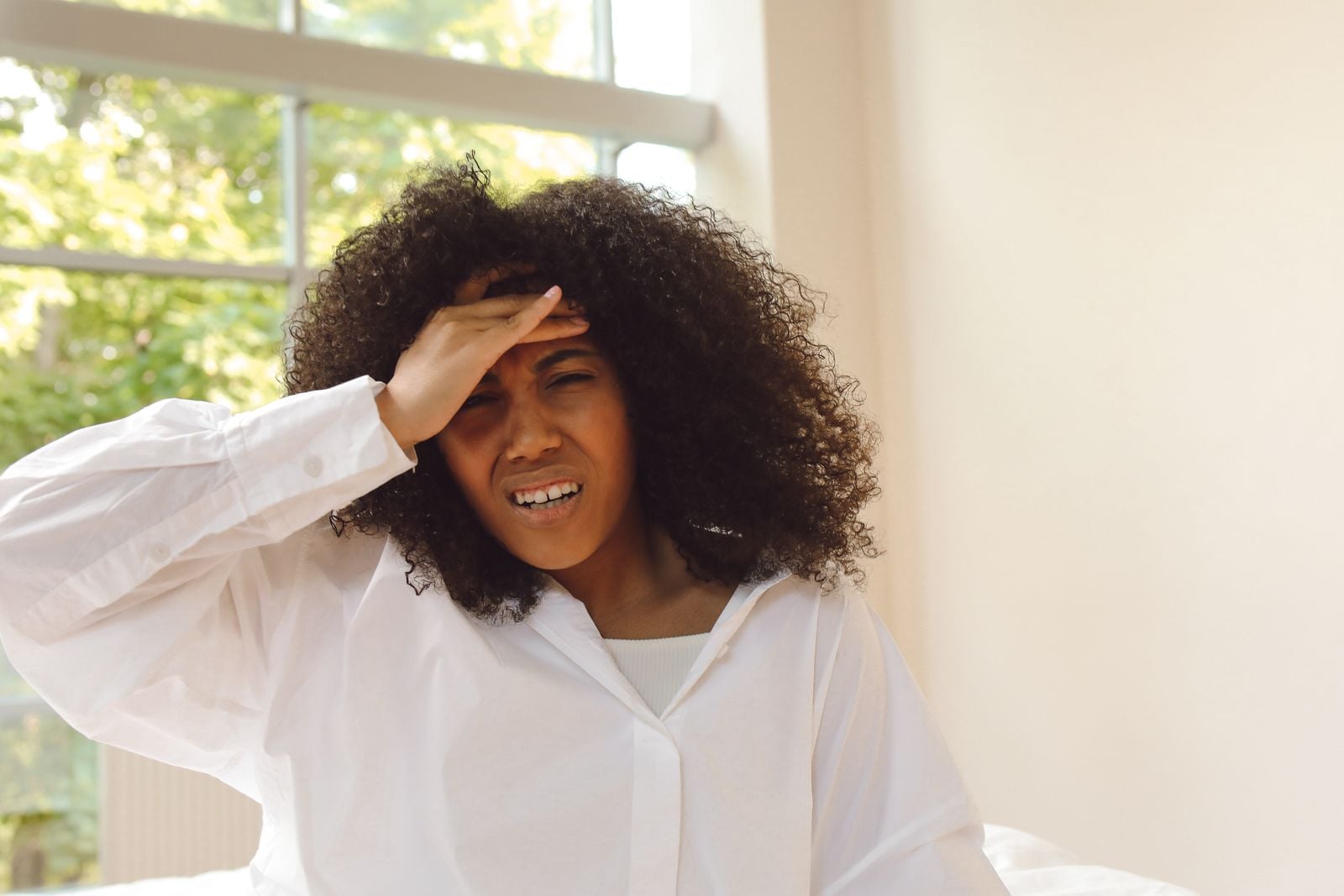 Woman holding her forehead in pain from a headache