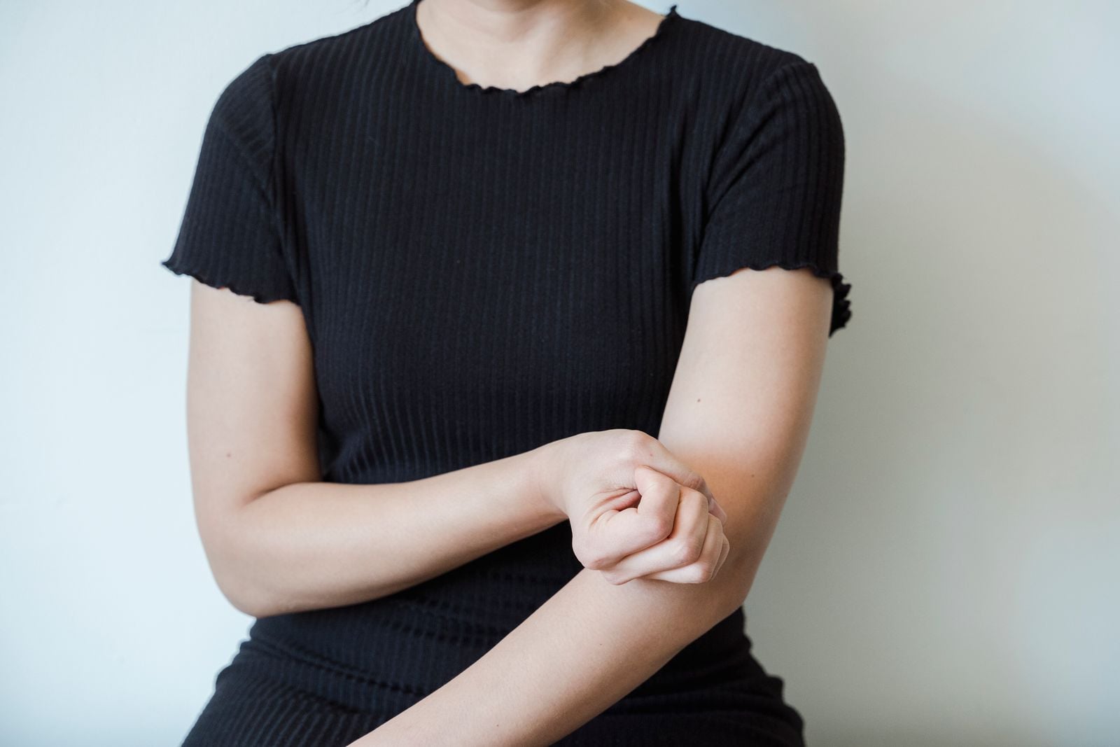 Person holding a sore forearm just below the elbow