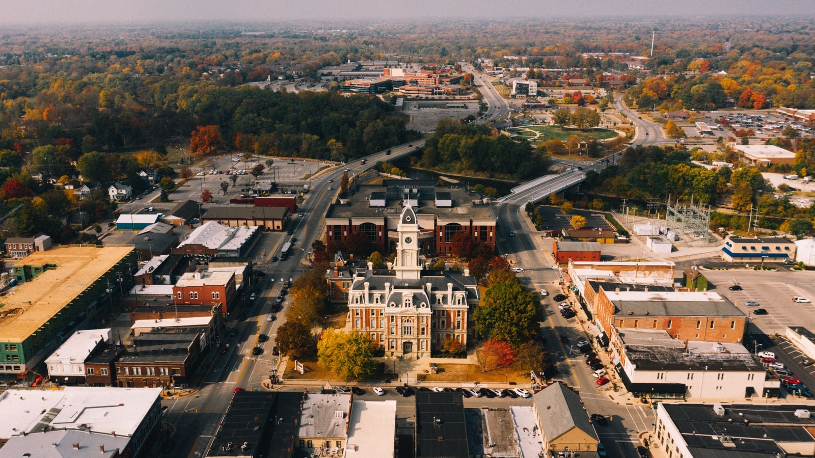 Aerial view of a historic town square with a clock tower in autumn
