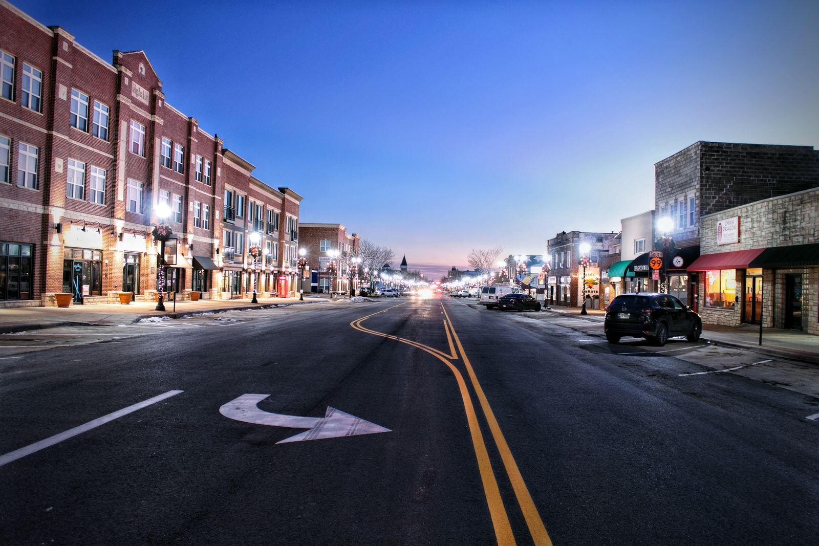 Downtown main street lined with brick storefronts at dusk