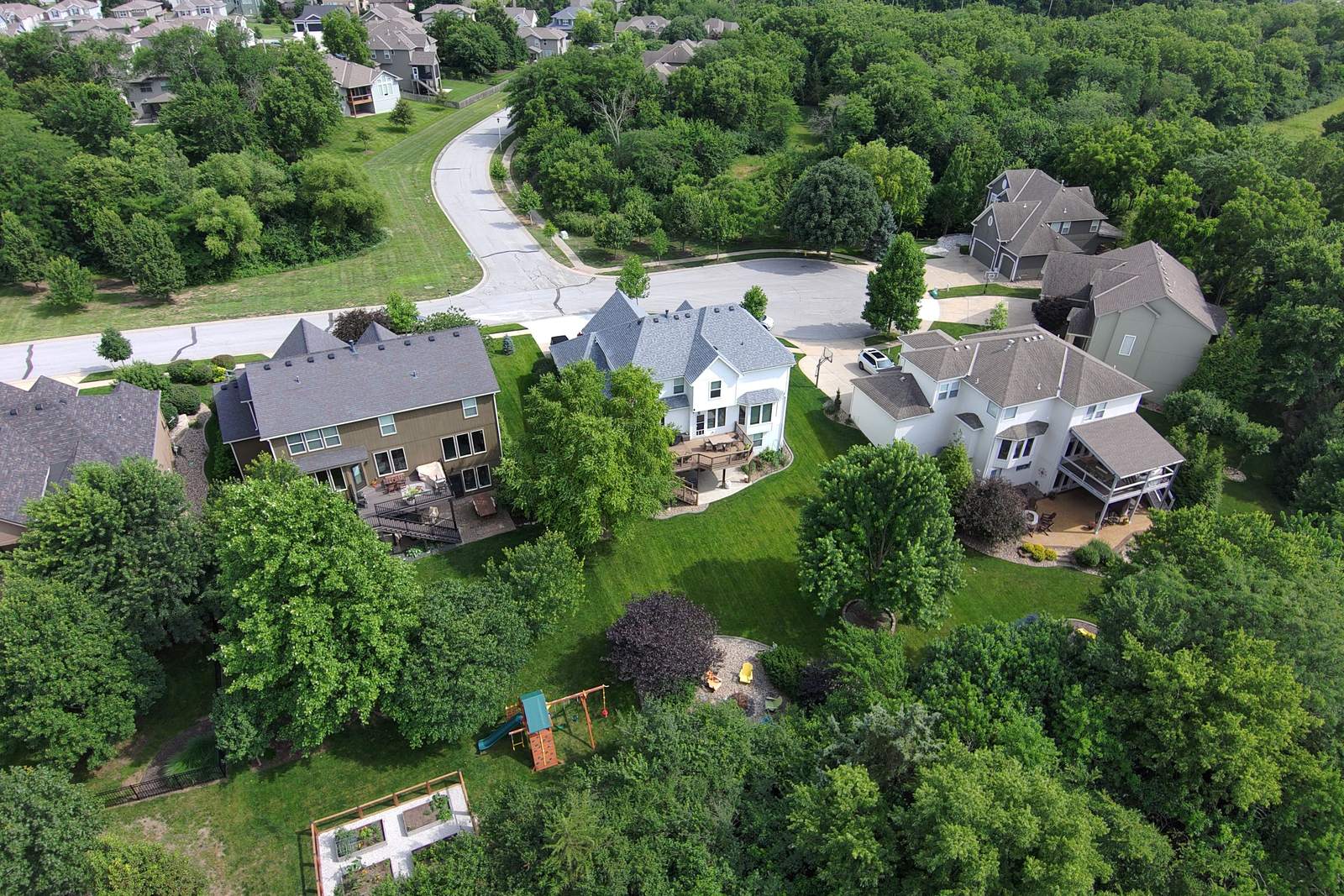 Aerial view of a leafy suburban neighborhood with green lawns