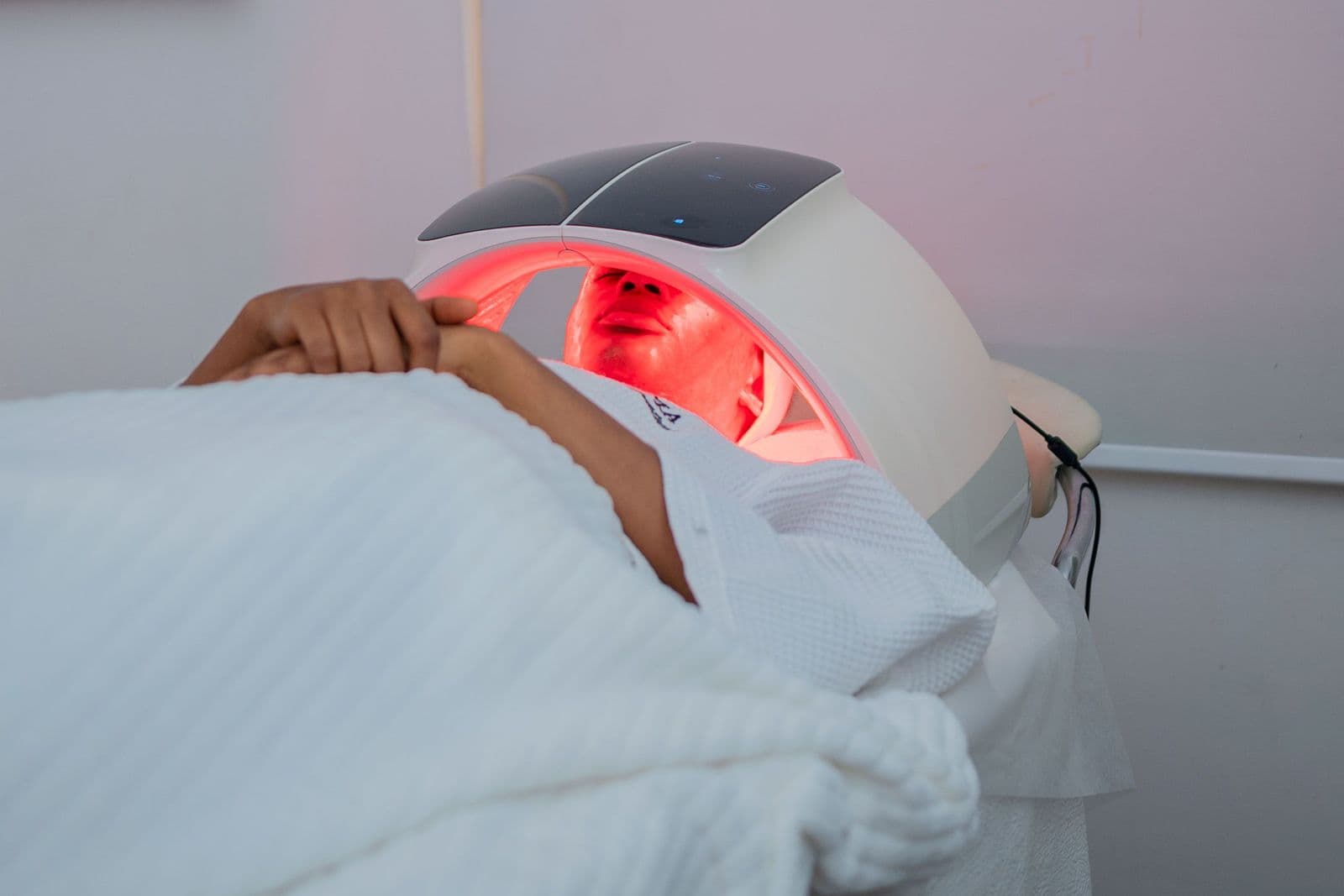 Illustrative stock photo of a person relaxing under a red LED light panel